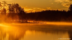 geel ochtendlicht schijnt over het mistige meer; yellow morning light shines over the misty lake