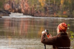 vrouw maakt een foto van de Kiutakongas stroomversnelling; woman takes a picture of the Kiutakongas rapids