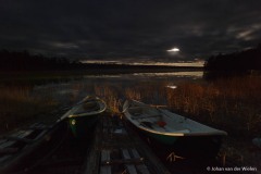 vissersboten liggen bij nacht aan het water; fishing boats at night on the water