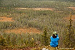 vrouw kijkt vanaf een hoge rots uit over het Finse landschap; woman looks from a high rock on the Finnish landscape
